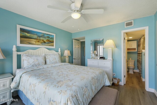 bedroom featuring dark hardwood / wood-style flooring, connected bathroom, ceiling fan, and a textured ceiling