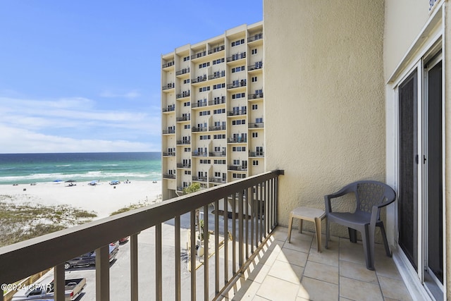 balcony with a water view and a view of the beach