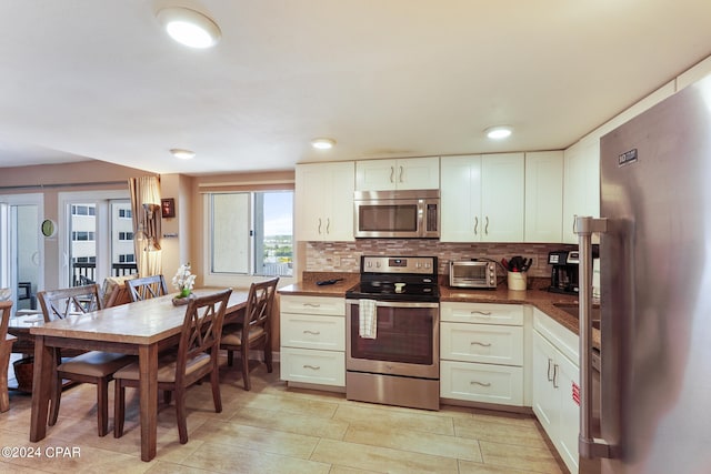 kitchen with tasteful backsplash, stainless steel appliances, and white cabinetry