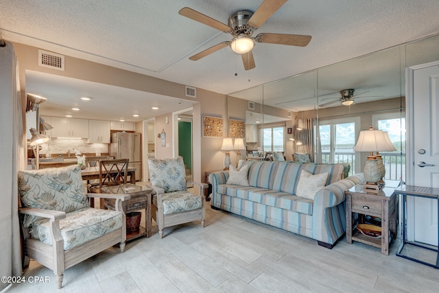 living room featuring a textured ceiling and ceiling fan