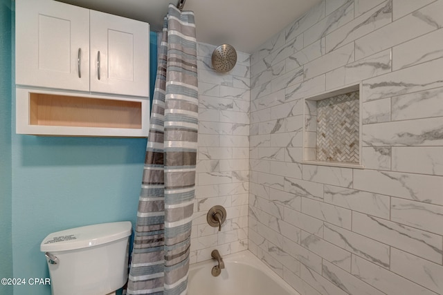 bathroom featuring shower / tub combo and toilet