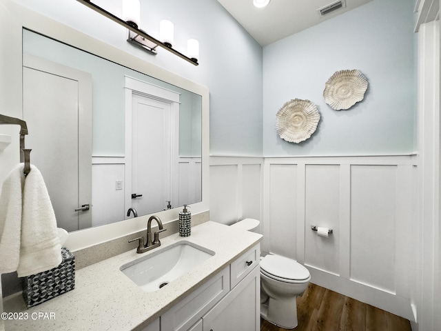 bathroom featuring toilet, vanity, and hardwood / wood-style flooring