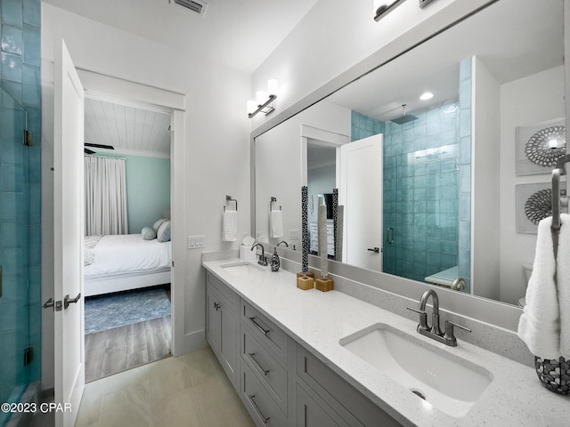 bathroom with hardwood / wood-style floors, vanity, and a shower with door