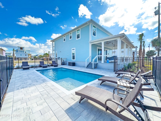 view of swimming pool featuring ceiling fan and a patio