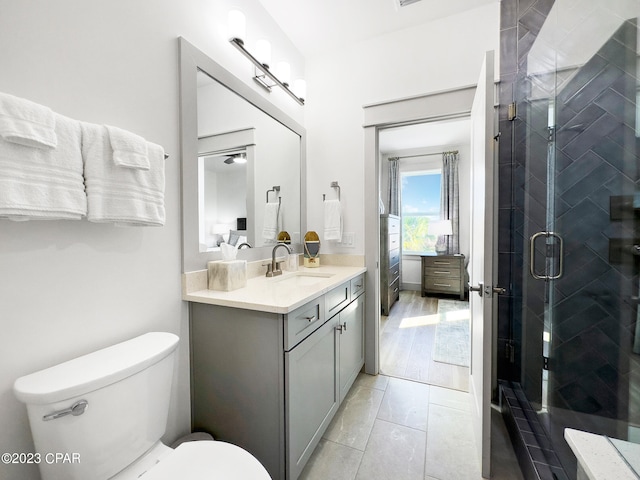 bathroom with vanity, toilet, and a shower with door