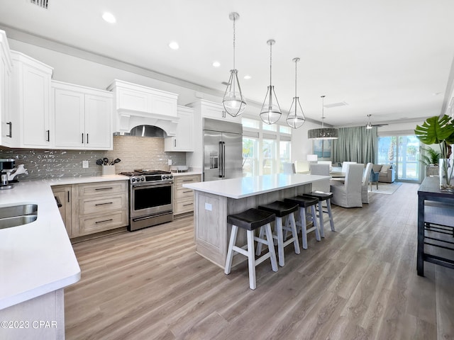 kitchen featuring white cabinets, a healthy amount of sunlight, a kitchen island, and appliances with stainless steel finishes