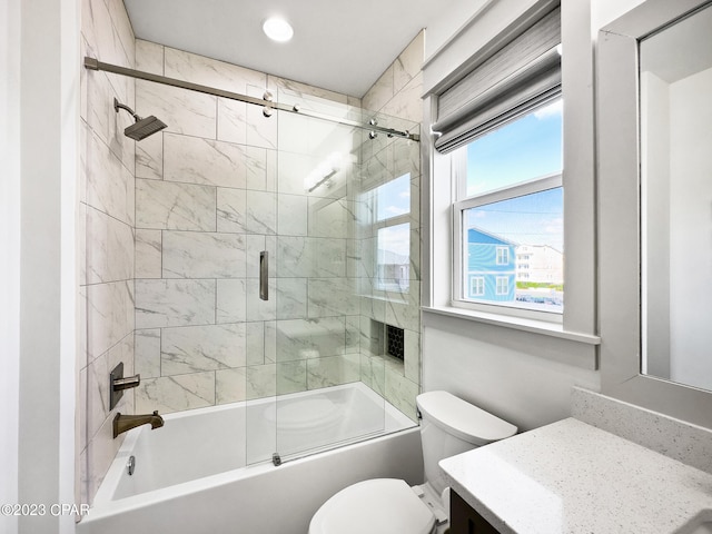 full bathroom featuring shower / bath combination with glass door, toilet, and vanity