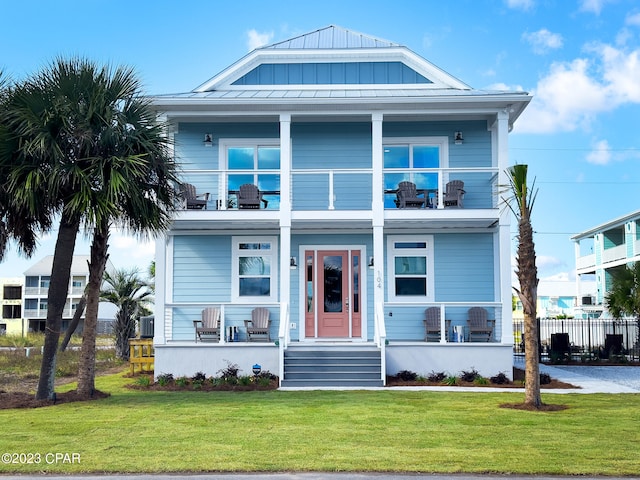 view of front of house featuring a front lawn and a balcony