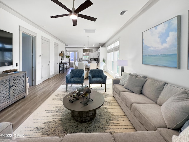 living room featuring ornamental molding, hardwood / wood-style flooring, and ceiling fan