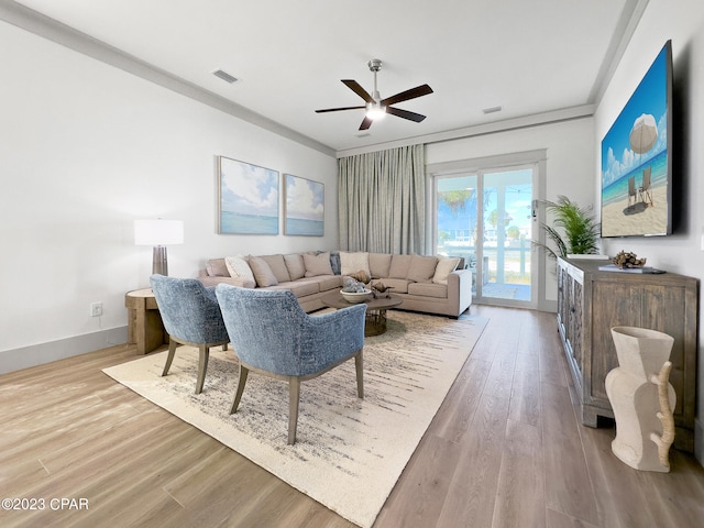 living room featuring ceiling fan, light hardwood / wood-style floors, and crown molding