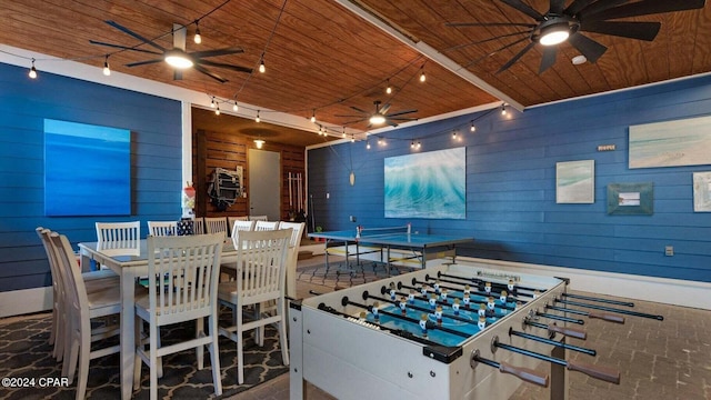 game room featuring wooden ceiling, ceiling fan, and wood walls