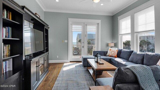 living room with ornamental molding, dark wood-type flooring, and a wealth of natural light