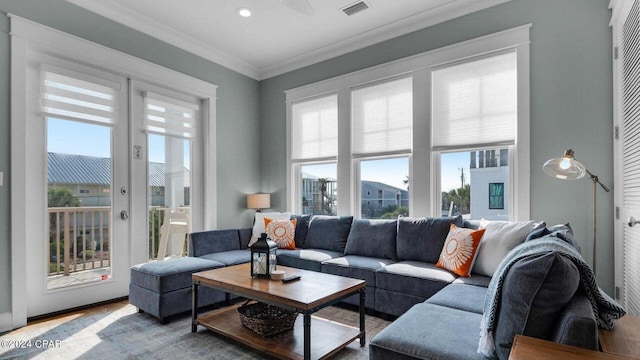 living room with hardwood / wood-style flooring, ornamental molding, and french doors