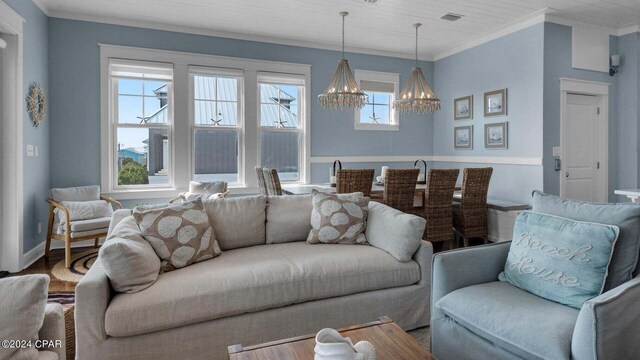 living room featuring crown molding, a chandelier, and hardwood / wood-style flooring