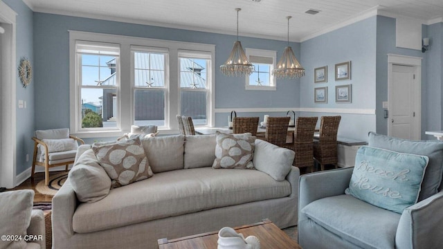 living room featuring ornamental molding, hardwood / wood-style floors, and a notable chandelier