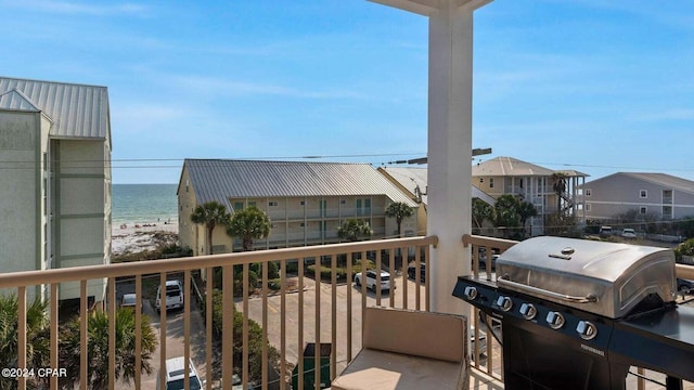 balcony featuring a water view, grilling area, and a view of the beach