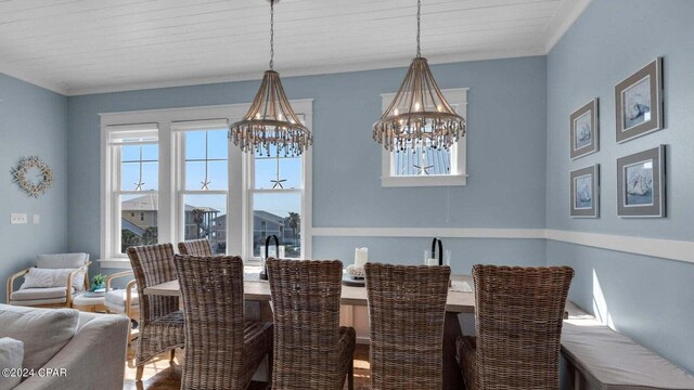 dining room with ornamental molding, hardwood / wood-style floors, and a notable chandelier