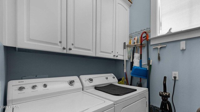 clothes washing area with cabinets and independent washer and dryer