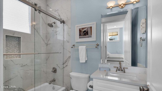 full bathroom featuring vanity, shower / bath combination with glass door, and toilet