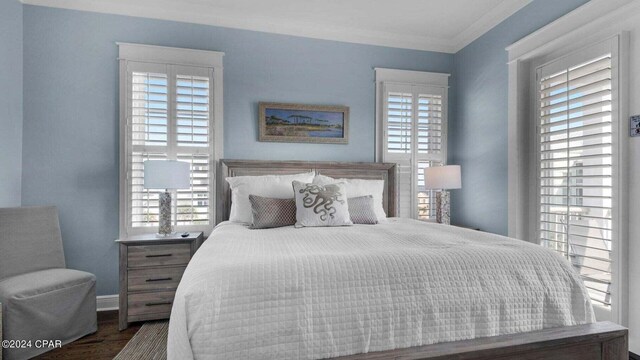 bedroom featuring multiple windows, crown molding, and dark hardwood / wood-style floors