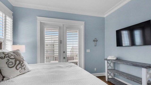 bedroom with dark wood-type flooring, ornamental molding, and french doors