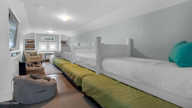 bedroom featuring hardwood / wood-style flooring and lofted ceiling