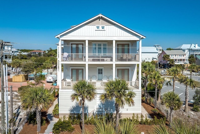 coastal inspired home featuring french doors and a balcony