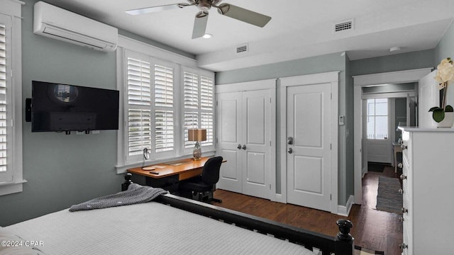 bedroom with ceiling fan, two closets, dark hardwood / wood-style flooring, and an AC wall unit