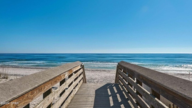 view of home's community featuring a water view and a beach view