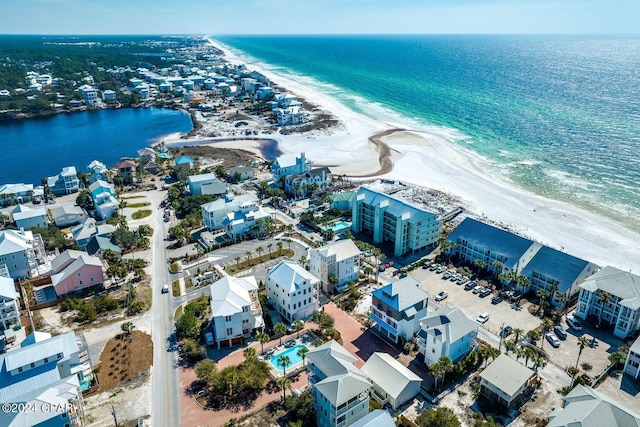 birds eye view of property with a water view and a beach view