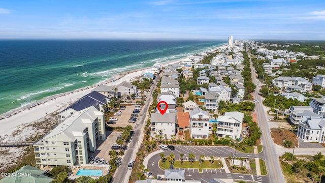 birds eye view of property with a water view and a beach view