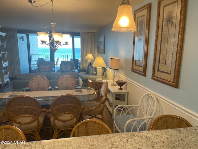 dining space featuring a water view and a notable chandelier