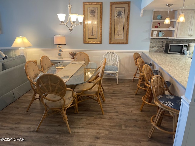 dining room with dark wood-type flooring and a notable chandelier