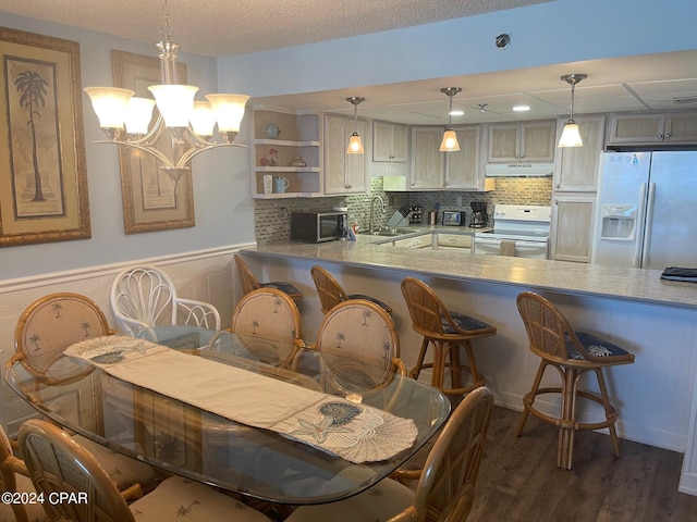 dining room featuring a chandelier, a textured ceiling, dark hardwood / wood-style floors, and sink