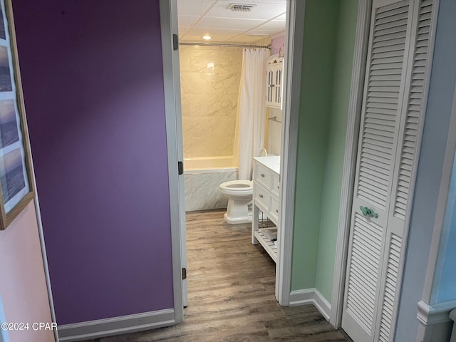 full bathroom with hardwood / wood-style flooring, shower / bath combo with shower curtain, vanity, and toilet