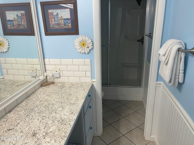 bathroom featuring tile patterned floors, vanity, and a shower with door