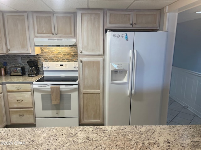 kitchen with decorative backsplash, light brown cabinets, light stone counters, and white appliances