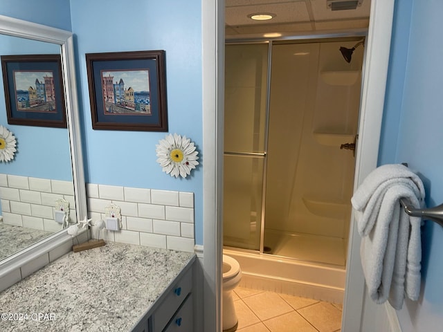 bathroom with tile patterned floors, toilet, decorative backsplash, vanity, and a shower with shower door