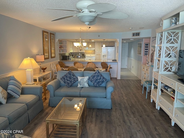 living room with ceiling fan, dark wood-type flooring, and a textured ceiling