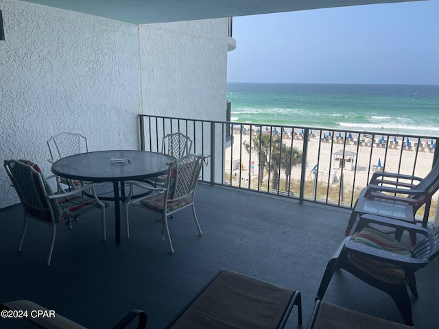 balcony featuring a view of the beach and a water view