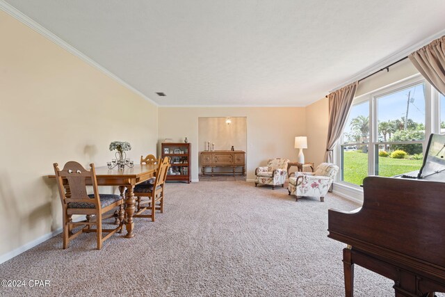 dining space with crown molding and carpet flooring