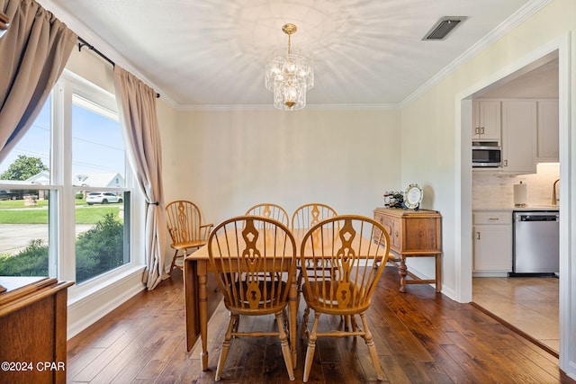 dining area with wood-type flooring, a chandelier, and ornamental molding