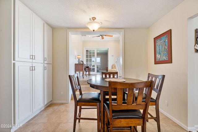 dining room with ceiling fan, a textured ceiling, and light tile floors