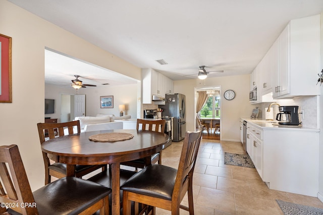 dining area featuring sink, ceiling fan, and light tile floors