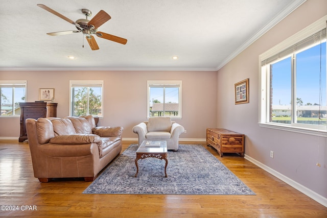 living room with plenty of natural light, ceiling fan, ornamental molding, and wood-type flooring