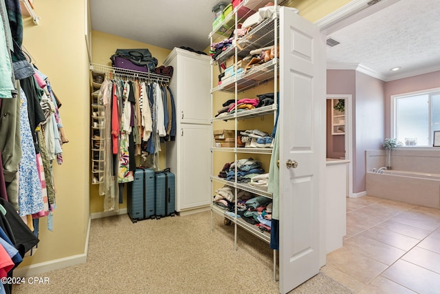 walk in closet with light tile floors