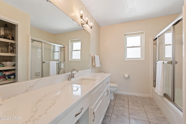 full bathroom with tile floors, a healthy amount of sunlight, bath / shower combo with glass door, and toilet