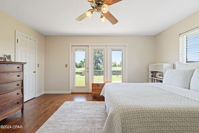 bedroom featuring access to exterior, a textured ceiling, dark hardwood / wood-style floors, and ceiling fan