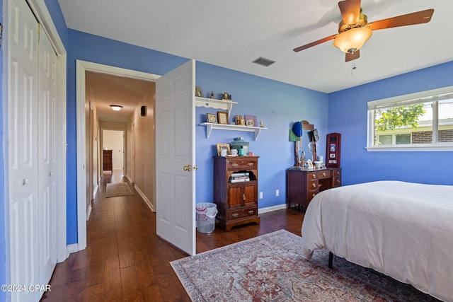 bedroom with dark hardwood / wood-style flooring, a closet, and ceiling fan