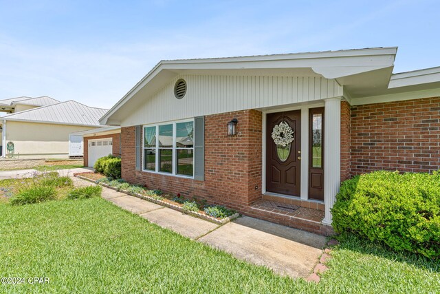 doorway to property with a lawn